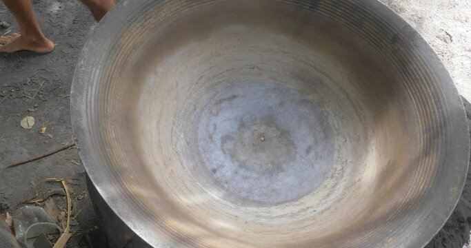 close up of a farmer put a huge pot over the khmer traditional stove used to boiling palm sugar