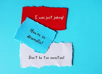 On blue background, torn paper with handwriting I WAS JUST JOKING, YOU'RE SO DRAMATIC and DON'T BE...