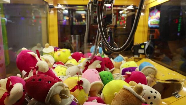 Colorful arcade game toy claw crane machine where people can win toys and other prizes which is located in the shopping mall