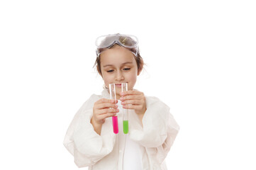 Smart preschooler girl, a young chemist scientist, lifting up test tubes with chemical liquid, showing the ongoing reaction inside while having chemistry class, isolated on white background. Ad space
