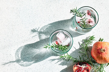 Pomegranate gin fizz cocktail with sparkling wine, rosemary and ice. Holidays refreshing alcoholic...