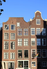 Fototapeta na wymiar Amsterdam Traditional Brick House Facades Overlooking the Oudezijds Voorburgwal Canal, Netherlands