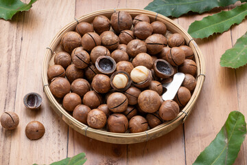 Macadamia nuts and Macadamia with hard shell on wooden background.