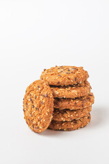 Oatmeal whole grain cookies with cereals isolated on white background. Stack of biscuits with sesame, sunflower and flax seeds close up