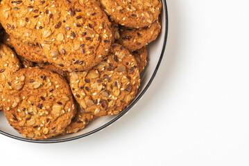 Cereal whole grain cookies with  sesame, sunflower, oat flakes and flax seeds  on white plate with copy space