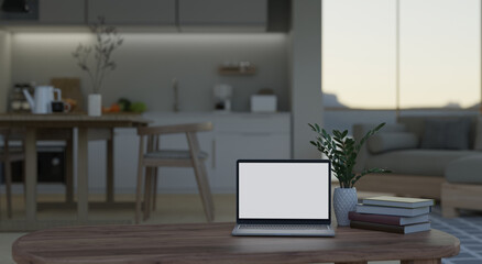 Home workspace with laptop on coffee table over blurred background of kitchen and dining room