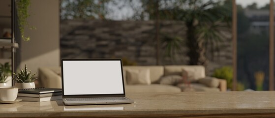 Home workspace with laptop and copy space on the table over blurred contemporary living room