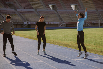 Three friends are working out together at the stadium