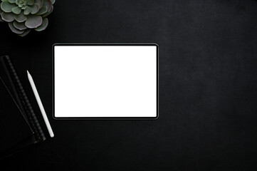 Stylish creative workspace top view with tablet mockup on black background.