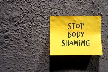 Grey cement concrete rough texture wall background with text STOP BODY SHAMING , no more humiliation about another body shape , size or criticizing appearance through negative judgment - obrazy, fototapety, plakaty