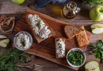 Roasted rye bread with cottage cheese salad on wooden table. Flat lay