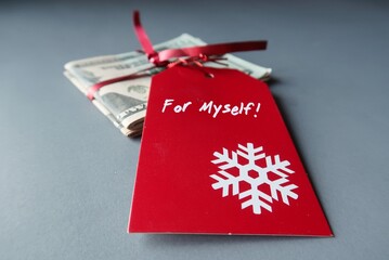 Cash dollars money in red ribbon with red xmas gift tag written text FOR MYSELF - concept of...