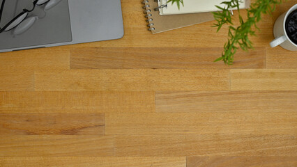 Workspace top view with copy space on wooden tabletop with laptop, coffee cup, stationery