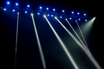 Fototapeta na wymiar Blue and white concert stage lights on black background