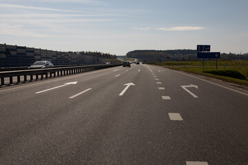 Fototapeta premium Highway wide road, transport and blue sky with clouds on a summer day