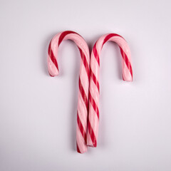 Two red candy canes on a white background