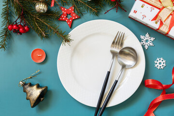 Flat lay of Christmas table setting with plate, cutlery, gifts boxs and christmas decorations on...
