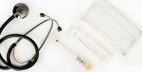 Electronic modern thermometer, medical mask, stethoscope and throat spray on a white background. Thermometer.