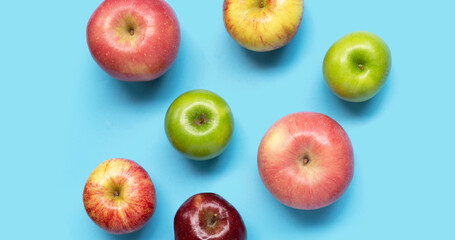 Various types of apples on blue background.
