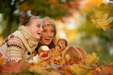 Portrait of nice grandmother of granddaughter in autumn