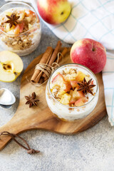 Obraz na płótnie Canvas Homemade dessert with yogurt, granola, caramel apples and cinnamon on a stone table. Healthy breakfast granola, healthy lifestyle.