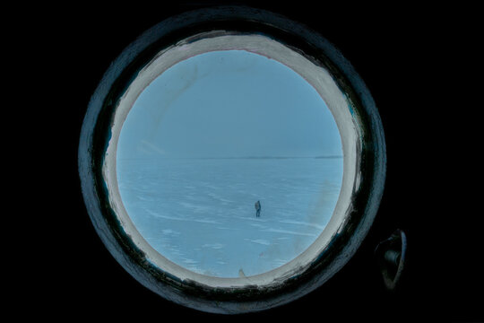 Man walking on Ice as seen from Inside an Artctic Explorer Ship, Swedish Lapland, North Sweden