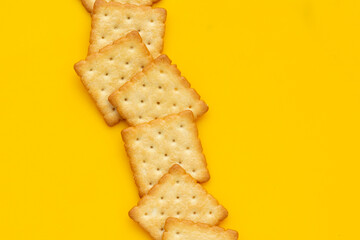 Dry cracker cookies on yellow background.