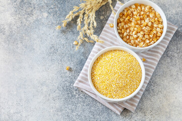 Food gluten free ingredient. Corn groats and seeds over gray stone background. View from above. Copy space.