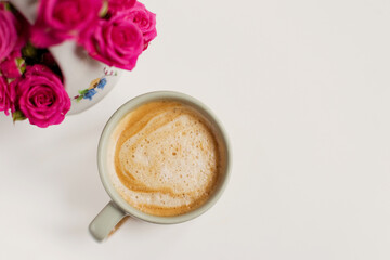Cup with coffee and pink flowers