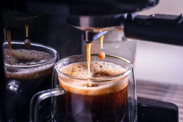 coffee in a glass, espresso crema comes out of the fully automatic coffee machine, Making the coffee machine into a cup.