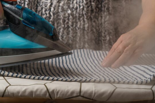 woman ironing a striped T-shirt while steaming