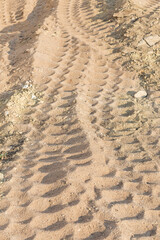 Fototapeta na wymiar Wheel tracks on sand dirt
