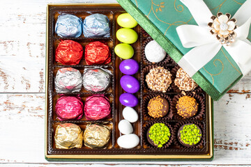 Packed gift chocolate. Pack of mixed chocolates on wood background. Top view