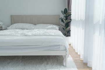 White bedroom with white curtains and white pillows