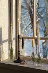 old window with winter landscape and burning candles on windowsill