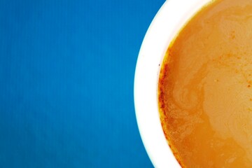 Media taza blanca de bebida de capuchino caliente en el bar de la ciudad con espuma flotando en la...