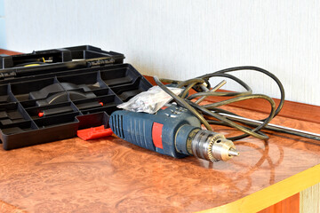 Carpenter's tools, drill, screwdrivers and toolbox on the table.