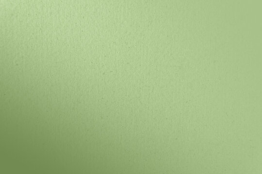 Soft plain pale soft leafy green color paint gradation on recycled cardboard box blank paper texture minimal background with space
