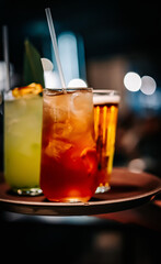 glasses alcohol cocktail set and beer on a waiter tray in bar