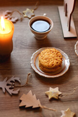 Fototapeta na wymiar Two types of cookies, cups of tea or coffee, various Christmas decorations and lit candles. Cozy Christmas atmosphere at home. Selective focus.