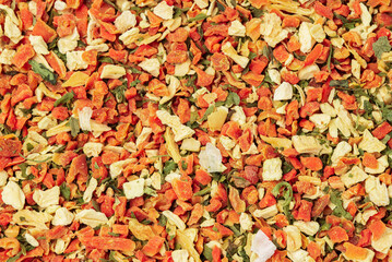 Layer of mixed pieces of dried carrots, celery root and greens with as food background.  Dehydrated...
