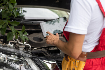 mechanic using digital tablet in workshop