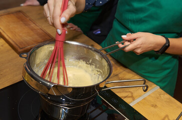 Cooking process: whisking sauce in a saucepan with rising steam