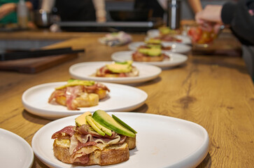 Toast with bacon and avocado on a plate standing on a wooden table