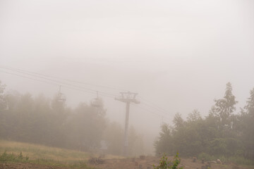 Old abandoned ski lift in mountain. Foggy mood.