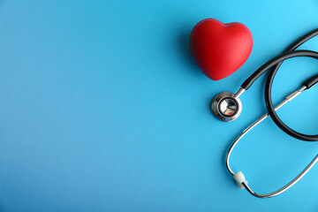  red heart and stethoscope are on blue background top view with copy space