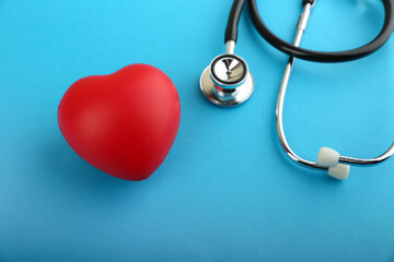 red heart and stethoscope are on blue background top view