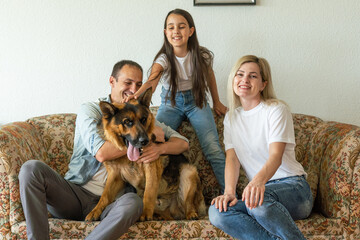 Portrait of happy family with a dog having fun together at home