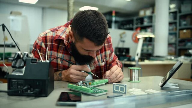 Electronics engineer repairing  device with iron soldering and tin wire