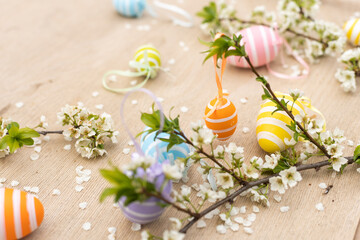 Happy Easter. Easter eggs on rustic table with cherry blossoms. Natural dyed colorful eggs and spring flowers. Countryside still life